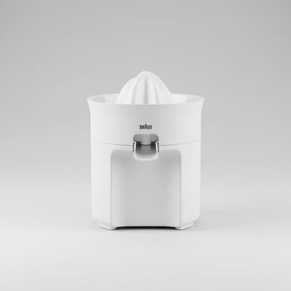 Braun citrus juicer on a kitchen counter with fruits and juice.